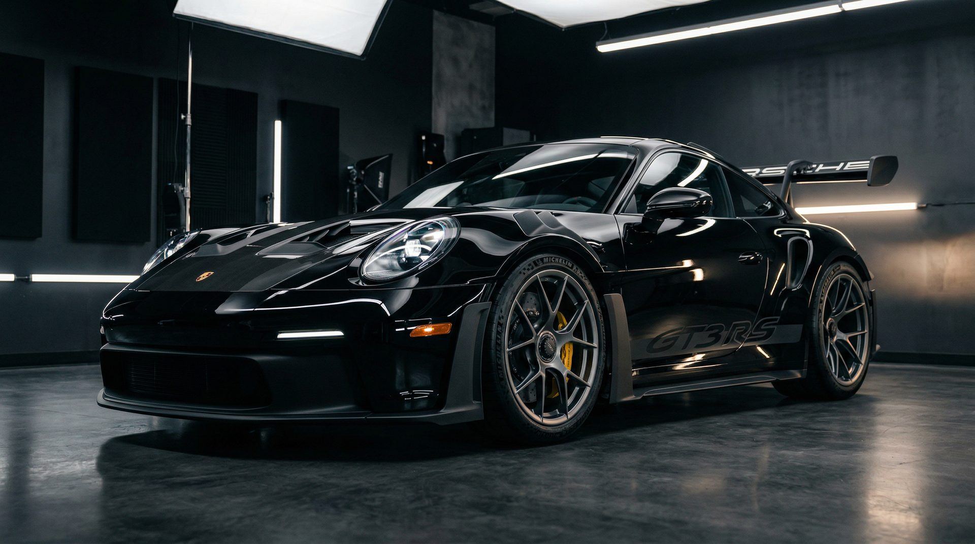 Gleaming black sports car with ceramic coating in a professional detail studio